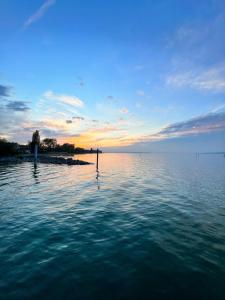 - une vue sur une grande étendue d'eau au coucher du soleil dans l'établissement Luxus Studio Apartment am Bodensee, à Güttingen