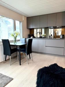 - une cuisine avec une table, des chaises et un comptoir dans l'établissement Luxus Studio Apartment am Bodensee, à Güttingen