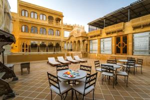 a patio with tables and chairs and a building at Hotel Grand Khalifa in Jaisalmer