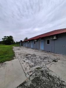 Guesthouse Sungai Musoh في بينجرانج: صف من المباني مع طريق ترابي أمامها