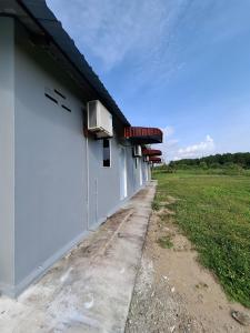 Guesthouse Sungai Musoh في بينجرانج: مبنى أبيض اللون مزود بمكيف هواء على جانبه +12 صورة
