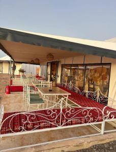 Zelt mit Tischen und Stühlen auf einer Terrasse in der Unterkunft Starlit Luxury Camp in Merzouga