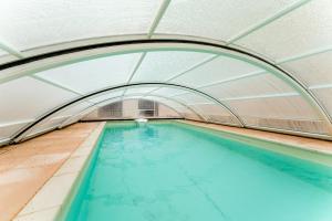 Chambre Laurier Rose في Piolenc: مسبح داخلي ذو مدخل مقوس ومياه زرقاء +17 صورة