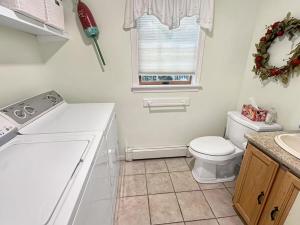 a white bathroom with a toilet and a window at Family Retreat at York Beach in York +29 photos