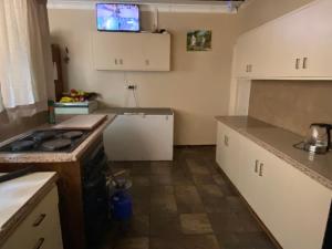 a kitchen with white cabinets and a stove top oven at Highway Haven in Stilfontein +23 photos