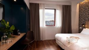 a hotel room with a bed and a window at Chic & Basic Velvet in Barcelona +32 photos