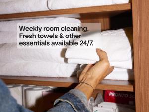 a person holding a sign on a shelf with towels at Numa Frankfurt Blau in Frankfurt/Main
