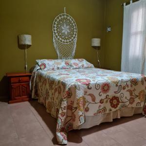 a bedroom with a bed with a patterned bedspread and a white head board at Complejo Ayllu in Las Rabonas