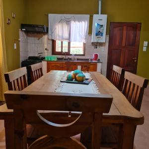 Cabañas Ayllu في لاس رابوناس: مطبخ مع طاولة خشبية عليها فاكهة