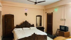 a bedroom with a large bed and a tv at JS Homestay in Nāgercoil
