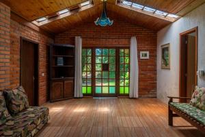 an open living room with a brick wall at Coração da Terra Praia do Rosa in Praia do Rosa
