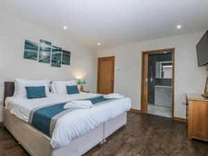 a bedroom with a large bed and a television at Benlli in Pwllheli