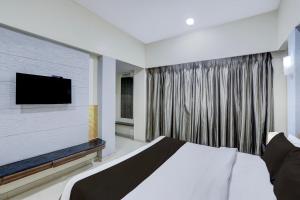 a bedroom with a bed and a large window at Townhouse Kakinada Nagamalli Thota Junction in Kākināda