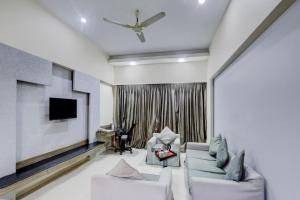 a living room with a couch and a tv at Townhouse Kakinada Nagamalli Thota Junction in Kākināda +46 photos
