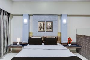 a bedroom with a large white bed and two lamps at Townhouse Kakinada Nagamalli Thota Junction in Kākināda
