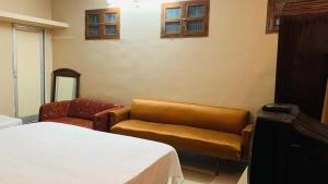 a hotel room with a bed and a chair at JS Homestay in Nāgercoil