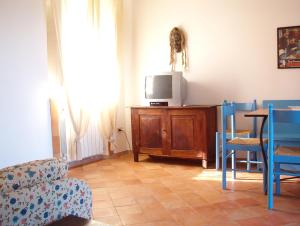 a living room with a tv and a table and chairs at Casa PAGLIERA in Porto San Giorgio