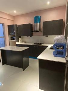 a kitchen with black cabinets and white counter tops at EXCLUSIVE ANSO Homes GRA Ikeja 1 bed room in Ikeja