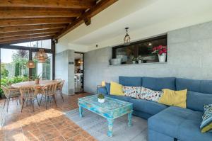 een woonkamer met een blauwe bank en een tafel bij Villa vacacional Taty in Llanes