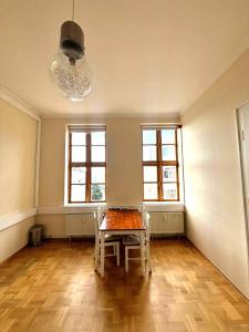 an empty room with a table and two windows at Markt Eins Salonwohnung in Schöppenstedt
