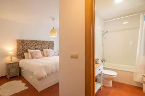 een slaapkamer met een bed en een badkamer met een toilet bij Villa vacacional Taty in Llanes +41 foto's