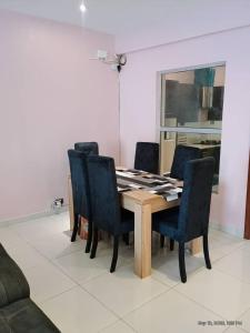 a dining room table with four blue chairs and a table at EXCLUSIVE ANSO Homes GRA Ikeja 1 bed room in Ikeja +6 photos