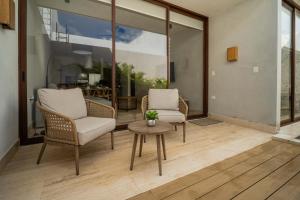 een woonkamer met twee stoelen en een tafel bij Luxury Designer Villa Pool & Gym in Cancun