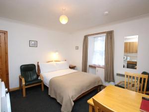 a bedroom with a bed and a desk and a chair at Orkney Studio Holidays in Kirkwall