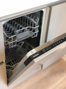 Un lavavajillas con la puerta abierta con un cuchillo. en Le nid - Centre ville - Capitole- Climatisé, en Toulouse