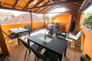 an outdoor patio with tables and chairs and a roof at Apartmani AE in Biograd na Moru