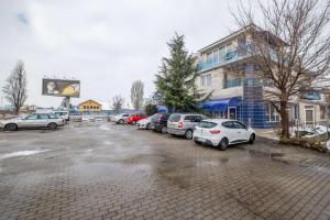 een parkeerplaats met auto's geparkeerd voor een gebouw bij Julia rooms in Sofia