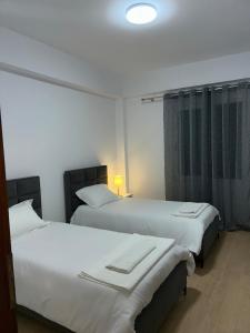 two beds in a hotel room with at Flat in Tirana - Modern & Cozy in Tirana