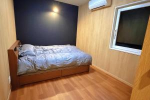 Habitación pequeña con cama y ventana grande. en A Lucky Hostel, en Hakuba 46 fotos más