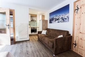 a living room with a couch and a kitchen at Ferienhaus zur Hackenschmiede in Mauterndorf