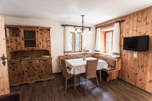 a dining room with a table and a tv at Ferienhaus zur Hackenschmiede in Mauterndorf