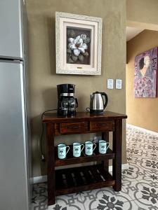 a table with a coffee maker and cups on it at La Luján Ayres de Campo in Luján