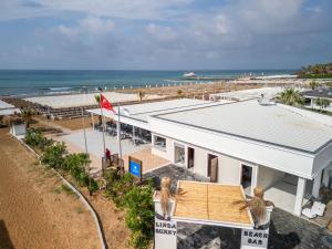 a building on the beach next to a beach at Linda Sunny Beach Hotel & Spa-Ultra All Inclusive in Side
