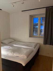 a bed in a room with a window at TotalApartments Skansegata Studio Apartments in Tromsø