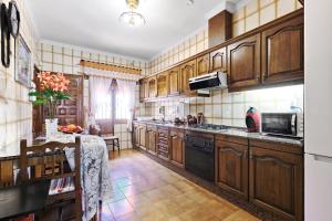 a large kitchen with wooden cabinets and a table at Villa en Lorca 2 Piscinas Vistas Gran Terraza y Barbacoa-Venta Ruizo Hasta 20 personas in Lorca