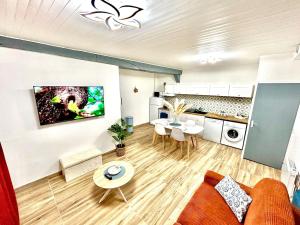 un salon avec un canapé et une cuisine dans l'établissement L'Envolée, centre ville parking gratuit, à Villeneuve-sur-Yonne 29 autres photos