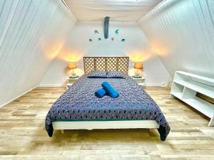 une chambre avec un lit avec des oreillers bleus dessus dans l'établissement L'Envolée, centre ville parking gratuit, à Villeneuve-sur-Yonne