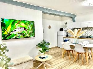 Il comprend une cuisine et une salle à manger avec une table et une télévision murale. dans l'établissement L'Envolée, centre ville parking gratuit, à Villeneuve-sur-Yonne