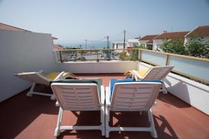 two chairs sitting on a balcony with a view at Vilas de Ribamar in Ribamar