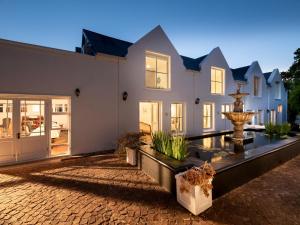 a house with a courtyard with a fountain at La Jolie Dauphine Guest House in Franschhoek