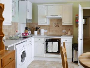 een keuken met witte kasten en een vaatwasser bij Pax in St Margarets at Cliff +7 foto's