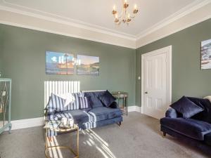 a living room with a blue couch and a chair at Jack's House- Uk40741 in Tywyn