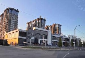 ein großes Gebäude mit zwei hohen Gebäuden im Hintergrund in der Unterkunft Смарт-квартира in Bucha