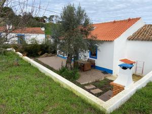 une petite maison blanche avec une table et un arbre dans l'établissement QUINTA DAS TEIMOSAS by Stay in Alentejo, à Cercal