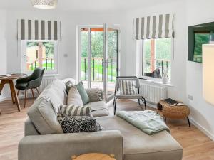 ein Wohnzimmer mit Sofa und Tisch in der Unterkunft The Rabbit Hole - Uk50123 in Bodelwyddan