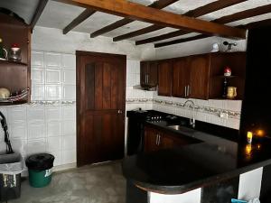 a kitchen with wooden cabinets and a black counter top at Tikki Lua in Cota